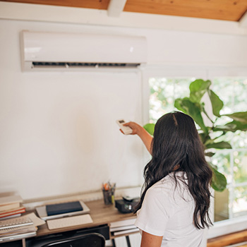 Woman operating air conditioning unit